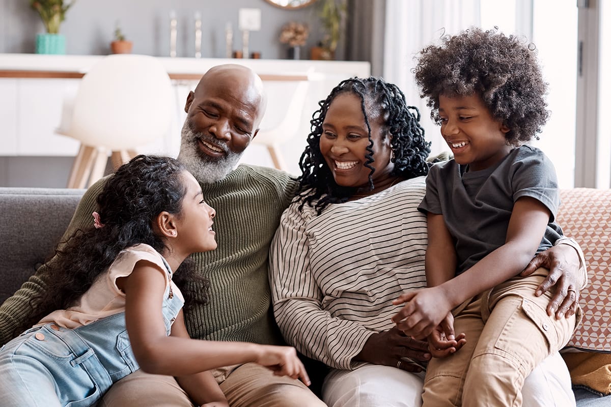 Familia sonriendo juntos en el sofá